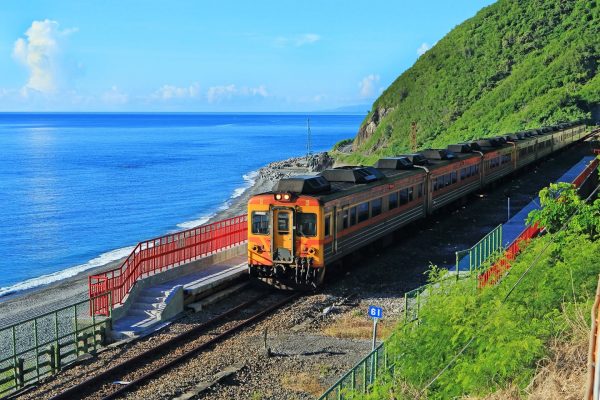ขบวนรถไฟแล่นเลียบชายฝั่งทะเลสีครามและทิวเขาเขียวขจีในไถตง บริเวณสถานีรถไฟตัวเหลียง