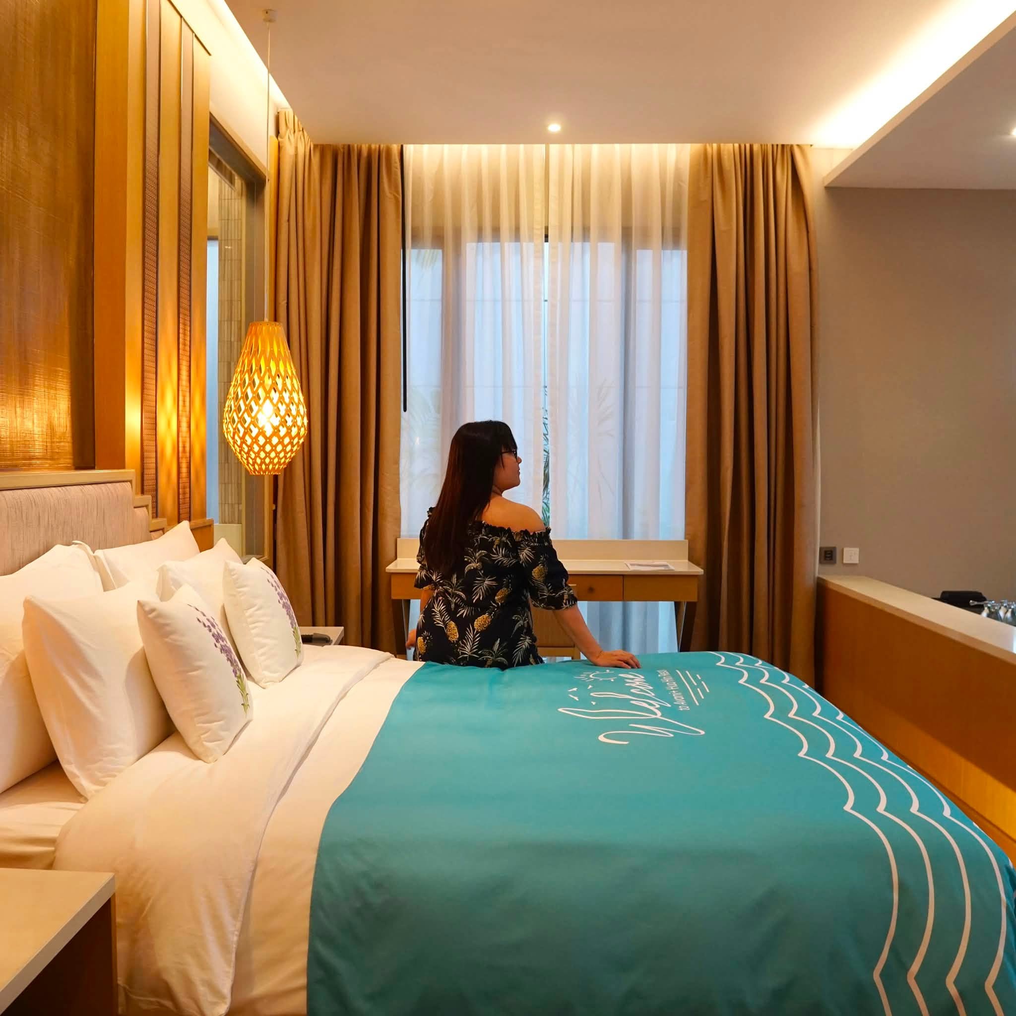 ภายในห้องนอน AVANI Lagoon Pool Villa ตกแต่งโทนไม้อบอุ่น พร้อมเตียงคิงไซส์และผ้าคาดเตียง Welcome