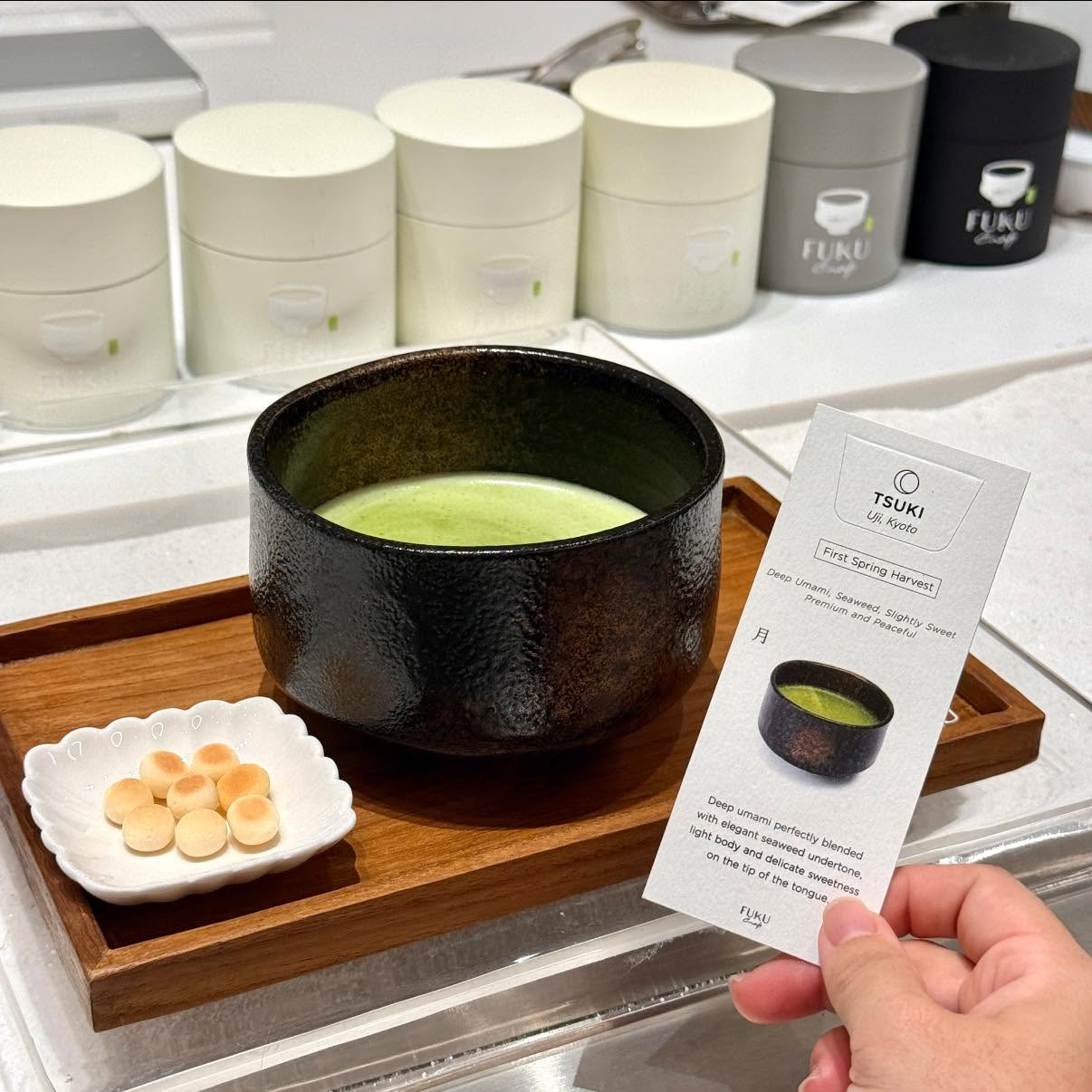 เซตชา Tsuki Hot Pure เสิร์ฟในถ้วยชาญี่ปุ่นพร้อมขนมทานคู่และการ์ดแนะนำสายพันธุ์ชา