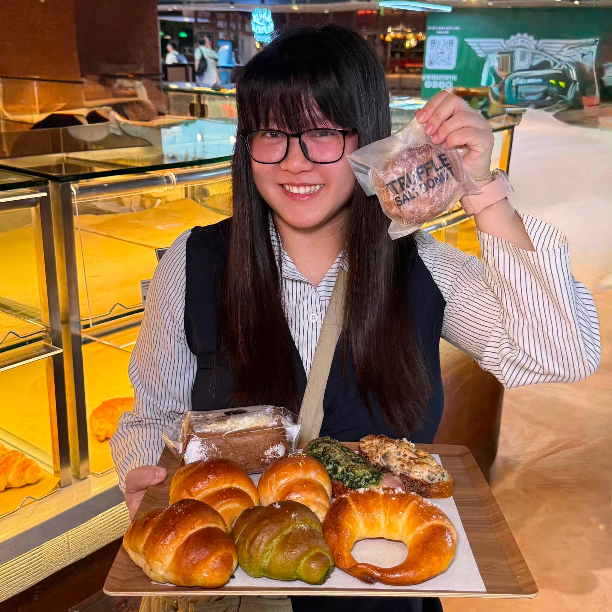 สองแว่นถือถาดรวมขนมปังและโดนัทของร้าน Truffle Bakery หลากหลายเมนูไฮไลท์